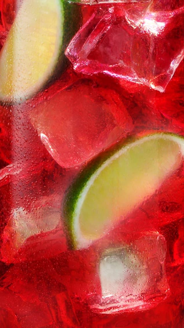 Red liquid on ice with lime