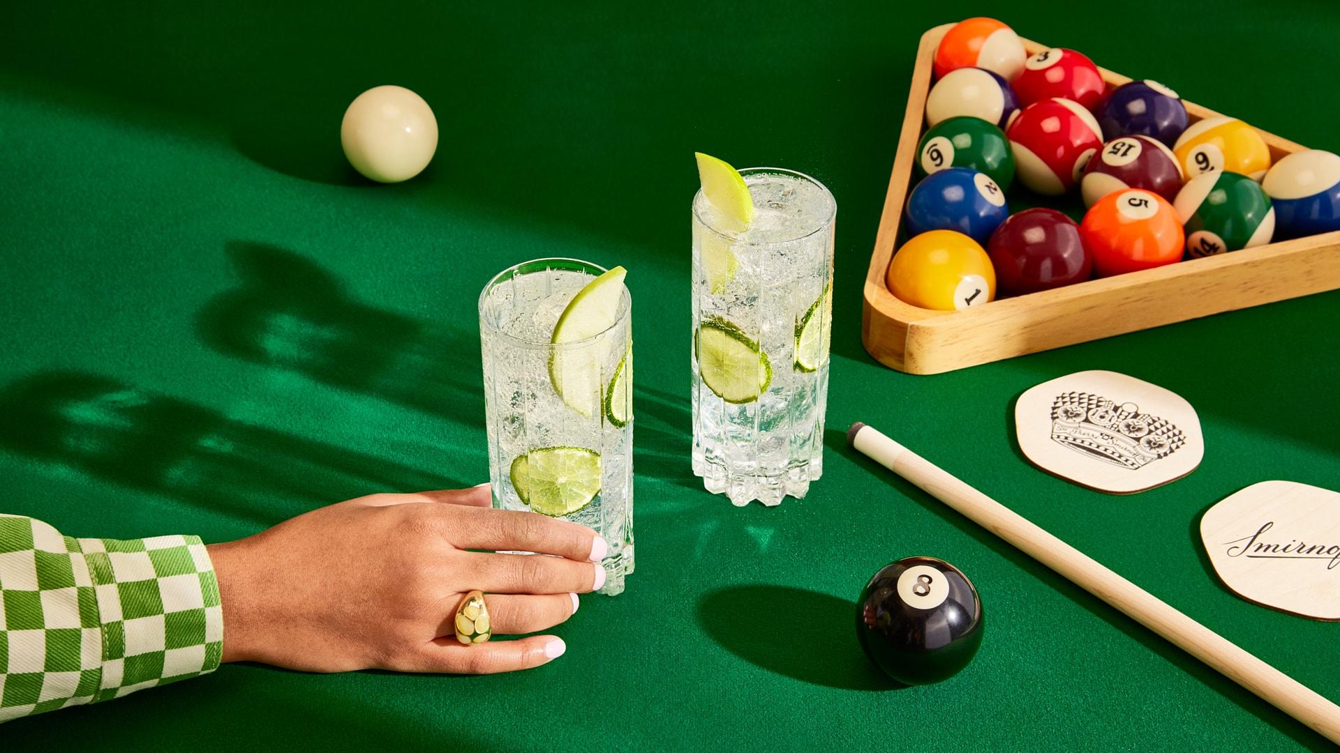 Two Smirnoff Green Apple Soda cocktails on a pool table