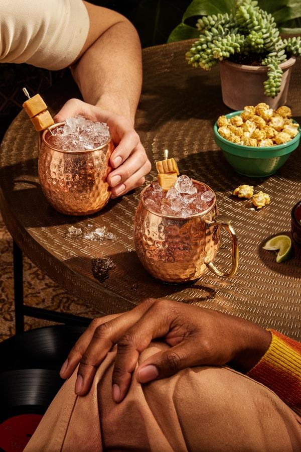 Two people drinking Smirnoff Kissed Caramel Mule cocktails