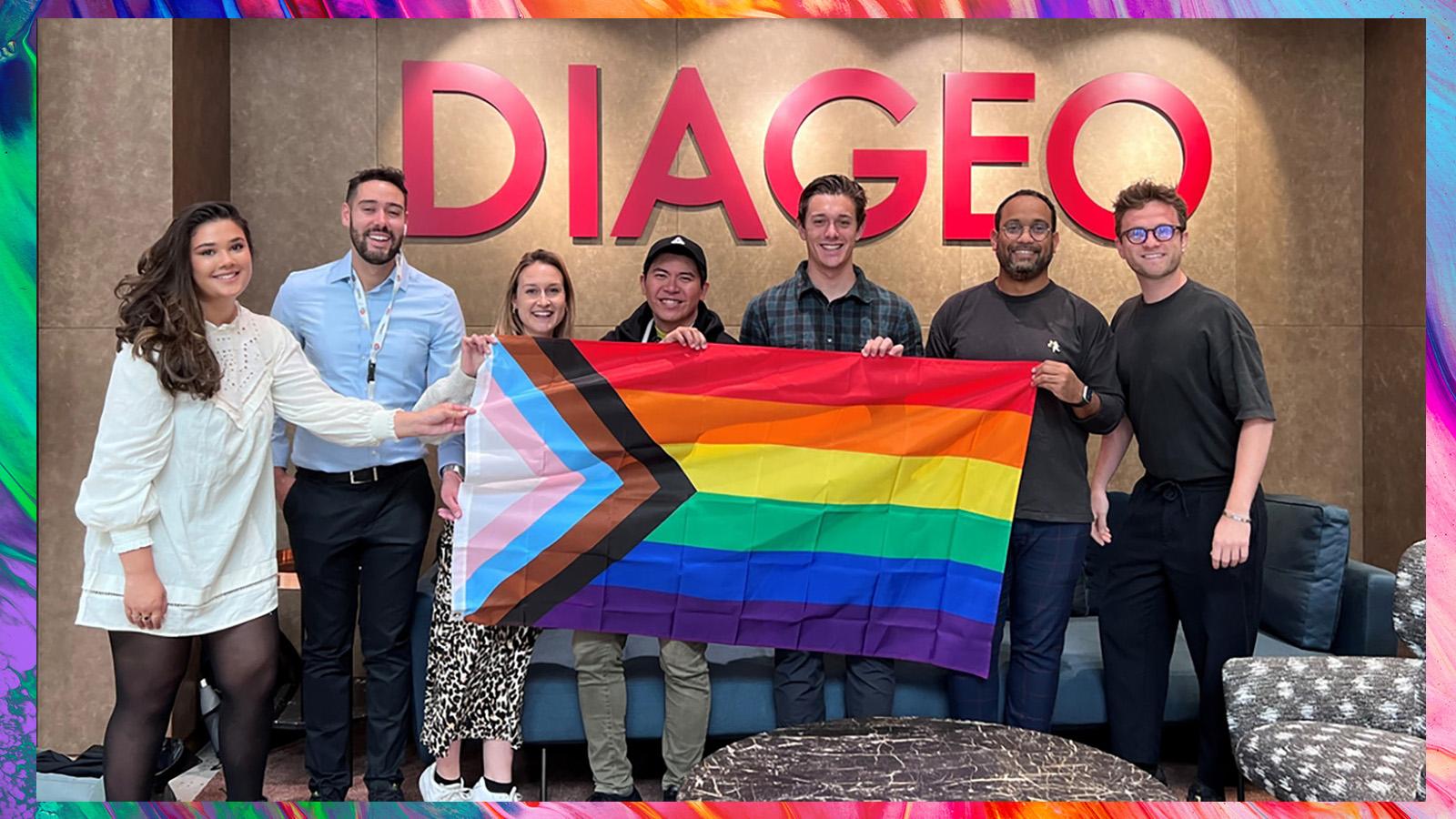 Diverse Diageo Employees holding rainbow flag.