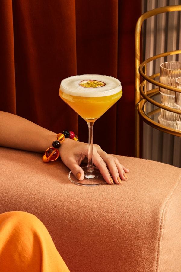 A woman enjoying a Passionfruit Martini Cocktail