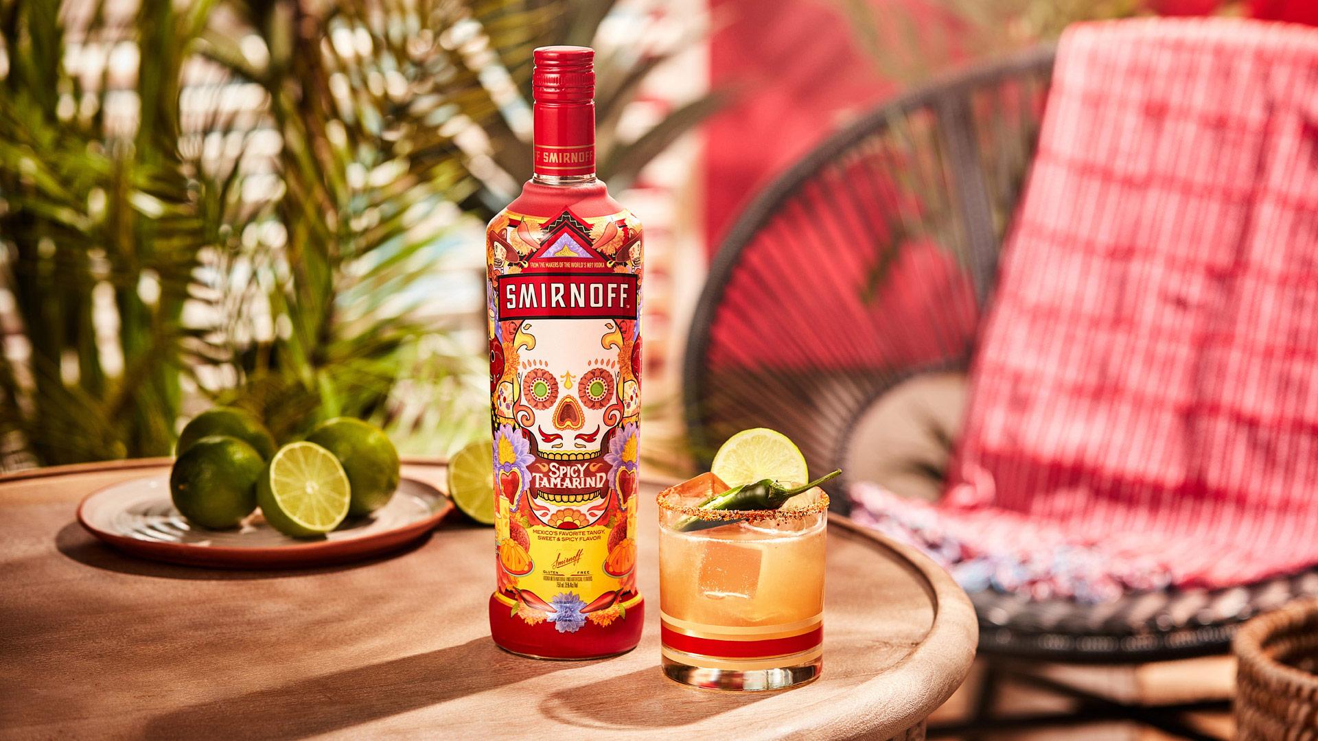 Smirnoff Spicy Tamarind vodka bottle alongside a Spicy Tama-rita cocktail, our take on the classic margarita  with a spicy seasoning rim,  lime wheel and jalepeno for garnish. 