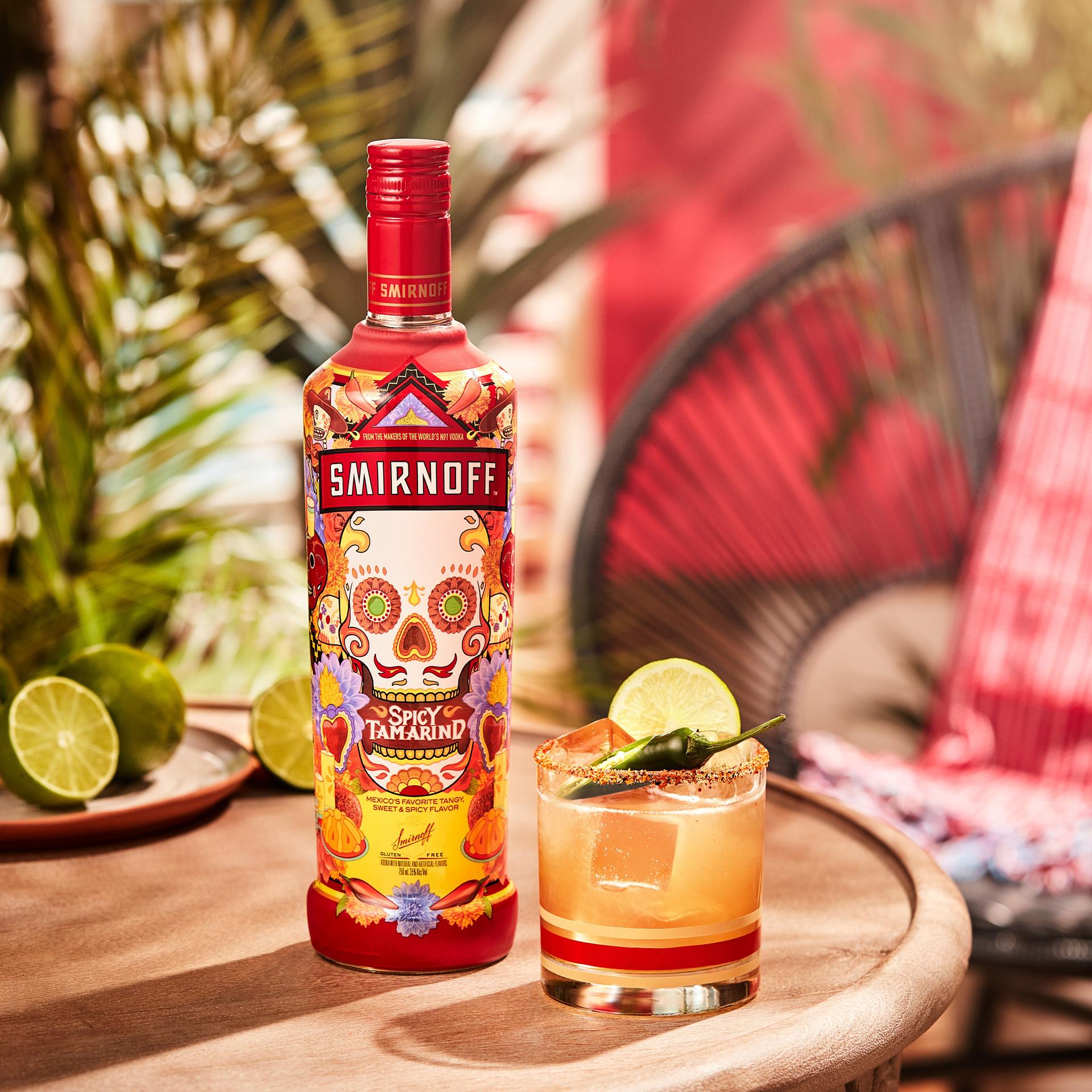 Smirnoff Spicy Tamarind vodka bottle alongside a Spicy Tama-rita cocktail, our take on the classic margarita  with a spicy seasoning rim,  lime wheel and jalepeno for garnish. 