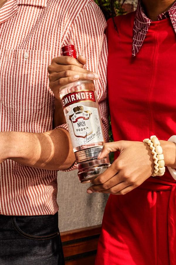 Two people standing near a Smirnoff 21 bottle